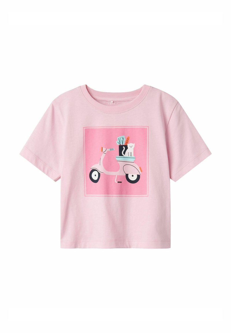 Rozā kokvilnas T-krekls ar grafiku, kas attēlo skūteri ar augu un kaķi kvadrātveida dizainā. Īsas piedurknes un apaļa kakla izgriezuma forma.