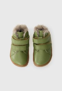 Groene leren peuterlaarzen met twee klittenbandbandjes, zachte beige bontvoering en bruine rubberen zolen. Gestructureerde bovenkant voor verbeterde grip.