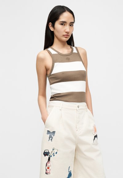 Débardeur côtelé rayé marron et blanc avec un col rond, associé à un pantalon beige à jambes larges orné de motifs brodés colorés.