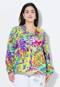 Kleurvolle lange mouw blouse in groen met abstracte paarse en rode patronen, V-hals en knoopaccenten. Zachte stof met een levendig ontwerp.