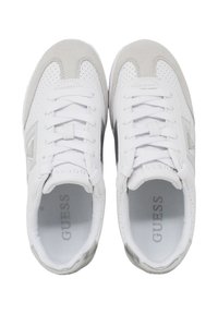 Un paio di sneakers bianche e grigio chiaro di Guess con chiusura con lacci, dettagli perforati e logo del marchio visibile sulla soletta e sui lati.
