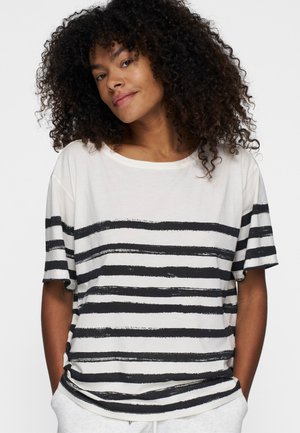 T-shirt bianco con ampie strisce orizzontali nere. Vestibilità ampia, maniche corte, scollo rotondo, realizzato in morbido cotone.