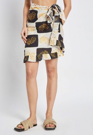 Kleid mit einem schwarz-weißen Muster und Rosenmotiven, Rüschensaum und einer Bindegürtel-Detail, aus einem leichten Stoff gefertigt.