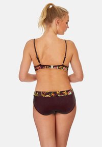 Ensemble de bikini de couleur bordeaux foncé avec des détails floraux sur la bande. Bretelles réglables et design à couverture modérée. Texture lisse.