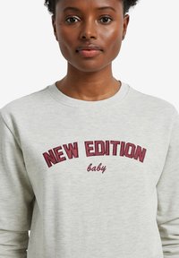 Hellgrauer Sweatshirt mit bordeauxrotem gesticktem Text "NEW EDITION baby." Klassischer Rundhalsausschnitt und lange Ärmel. Weiche Textur.