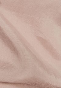 Tessuto rosa pallido con una superficie leggermente texture. Il materiale appare leggero e ha una leggera lucentezza, creando pieghe delicate.