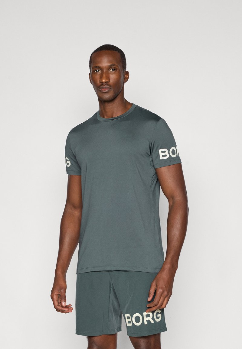 Dark green athletic t-shirt with short sleeves, round neckline, and white "BORG" logo on the left sleeve. Soft, smooth fabric; paired with matching shorts.
