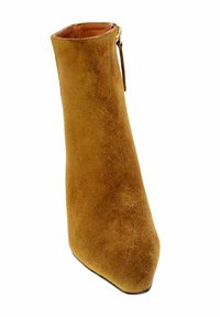 Stivaletto alla caviglia in suede beige con punta affusolata, gambale alto e zipper laterale. Texture liscia e silhouette elegante.