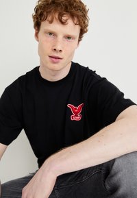 Levi's® VINTAGE FIT GRAPHIC - Apdrukāts T-krekls - black'