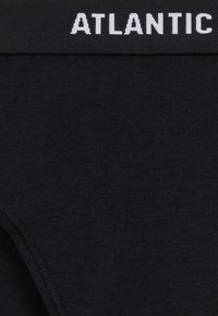 Czarna bawełniana bielizna z szerokim elastycznym pasem, na którym widnieje biały napis "ATLANTIC". Gładka faktura i prosty design.