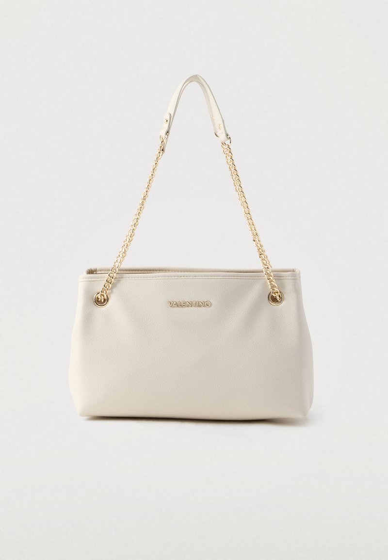 Bolso de piel color crema con asas de cadena dorada. Presenta un diseño sencillo y un logo de la marca visible en el exterior frontal.