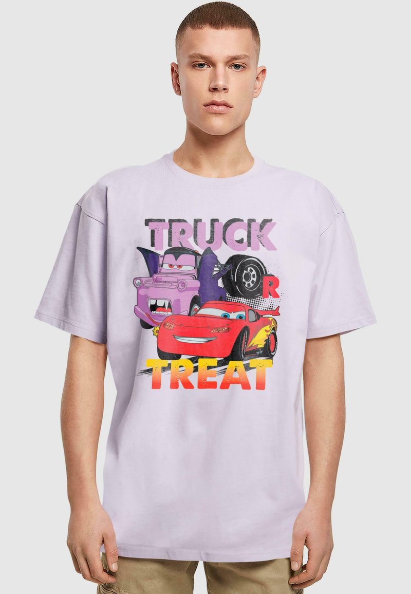 Laventelivärinen puuvillapaita, jossa on värikäs graafinen kuvasto autoista ja teksti "TRUCK OR TREAT". Irtonainen malli, lyhyet hihat, pyöreä kaula-aukko.