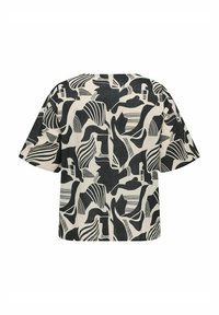 Blouse à manches courtes en tissu cream avec un motif abstrait noir comportant des formes ondulées et géométriques, coupe décontractée et ourlet droit.