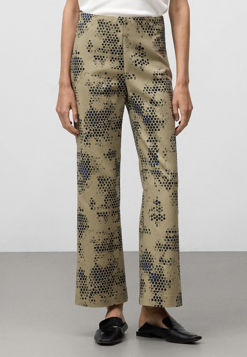 Beige wijde broek met een subtiel abstract patroon van zwarte en marineblauwe stippen. Glad stof met een lichte glans, met een hoge taille.