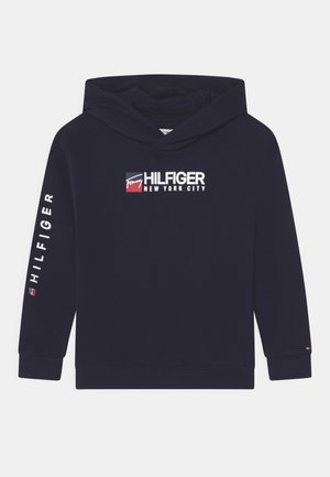 Granatowy, dresowy sweatshirt z kapturem z logo z przodu i białym tekstem na rękawach. Wykonany z miękkiego materiału, z ściągaczami przy mankietach i u dołu.