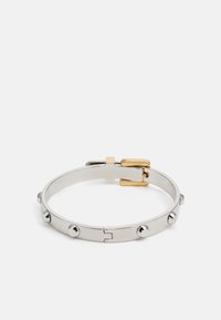 Pulsera de metal plateado con tachuelas circulares y un cierre en tono dorado. El diseño es elegante con una textura suave, creando un aspecto moderno.