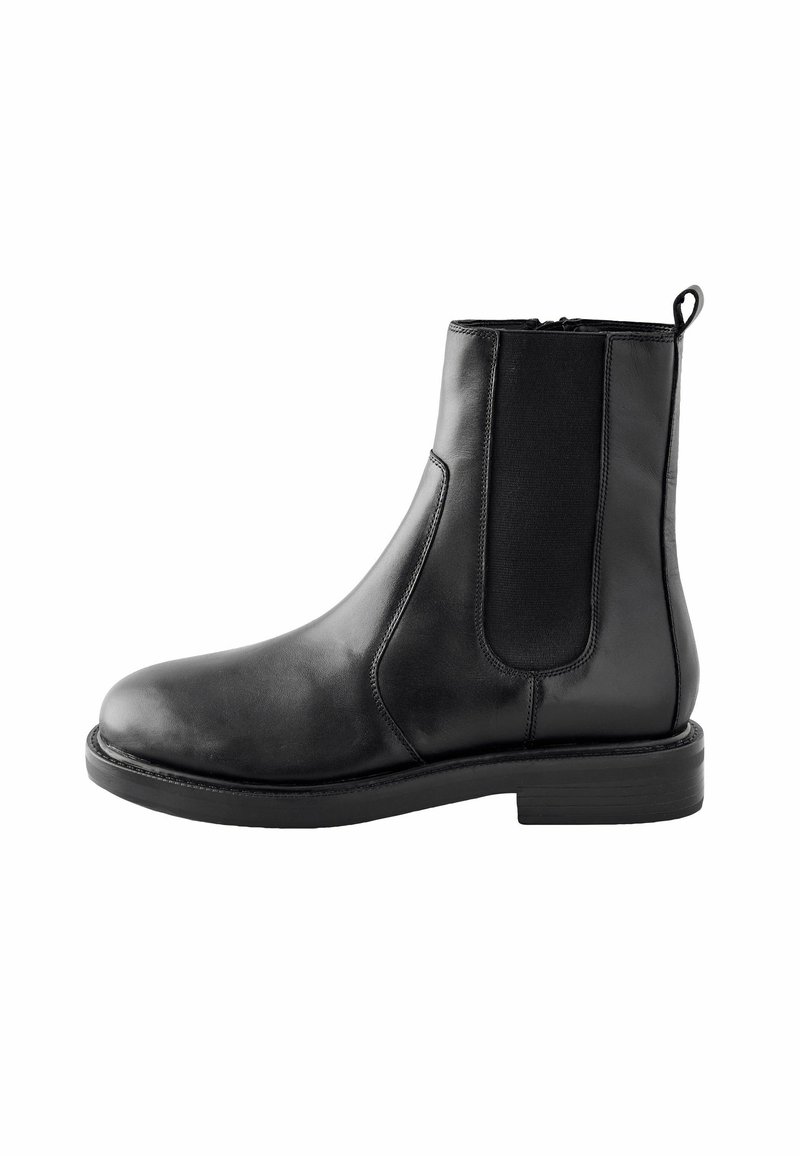 Bottine Chelsea en cuir noir avec panneau latéral élastique et languette de traction sur fond blanc.