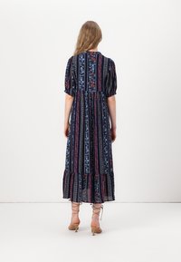Floral midi dress with short puff sleeves, navy background, vertical stripes in pink and blue, ruffled hem, and lightweight fabric.