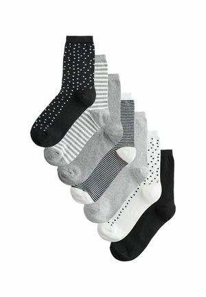 Eight pairs of socks displayed, featuring various colors: black, gray, and white, with patterns including polka dots and stripes.