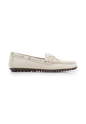 Mocassin beige en cuir avec bout mocassin, détail de lacets sur le dessus, œillets latéraux, et semelle en caoutchouc marron texturée pour une meilleure adhérence.