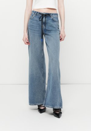 Light blue wide-leg jeans made of denim, featuring a black drawstring and front pockets. The hems are finished and sit above black shoes.