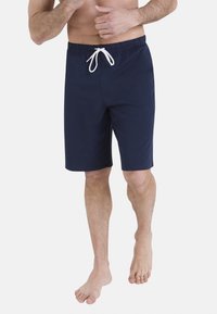 Shorts de bain bleu marine en tissu doux, dotés d'une taille élastique avec cordon de serrage et d'une coupe arrivant aux genoux.