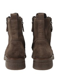 Hnědé suede kotníkové boty se zipovým zapínáním, texturovanou podrážkou a hladkým koženým akcentem. Design zahrnuje zaoblenou špičku a skromný podpatek.