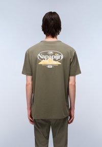 Olive green short-sleeve t-shirt featuring a mountain graphic and "Napapijri" logo on the back. Soft fabric with a relaxed fit.