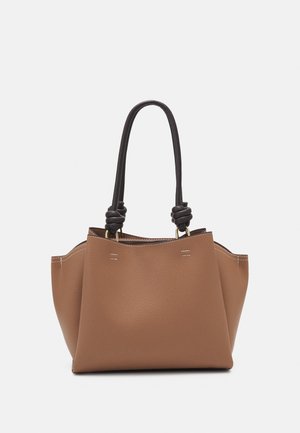 Sac cabas en cuir texturé marron avec poignées foncées nouées et coutures blanches visibles sur les côtés et les bords supérieurs.