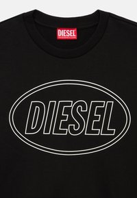 Μαύρο φούτερ με ριμπ λαιμόκοψη, λευκό οβάλ περίγραμμα με έντονο κείμενο "DIESEL" και κόκκινη ετικέτα της μάρκας στο εσωτερικό του γιακά.