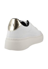 Nahar leather-sneaker, mille valge ülemise osa, mustade aktsentidega, pehme krae ja läikivast kuldse kanna detailiga, mis sisaldab logo. Paks valge kummitald.
