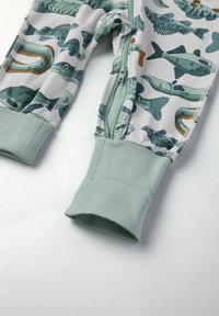 Kinderpyjama set van lichte stof met vis- en aquatische patronen, ritsluiting en mintgroene manchetten. Zachte, rekbare textuur.