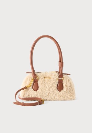 Kleine beige Handtasche aus Kunstfell mit braunen Ledergriffen und abnehmbarem Schultergurt, goldfarbener Hardware und Reißverschluss.