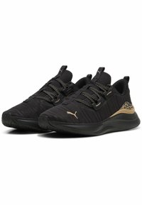Czarne buty sportowe z teksturowanym, dzianinowym wierzchem, złotymi akcentami i elastycznymi sznurówkami. Wygięta podeszwa z wzorzystym detalem na pięcie.