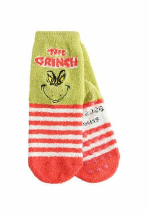 Gröna och röda randsrandiga halksockor med Grinchens ansikte och texten "The Grinch" på den övre delen.