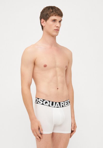 Weiße Boxershorts mit einem schwarzen "DSQUARED"-Logo auf dem elastischen Bund. Weicher Stoff, figurnaher Schnitt und mittellange Oberschenkel.