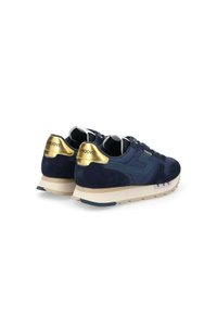 Baskets bleu marine avec dessus en suède et en mesh, accents dorés sur le talon, lacets blancs et semelle beige. Texture légère avec un design superposé.