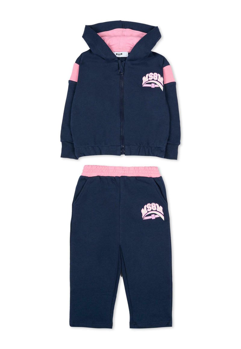 Marineblauwe zip-up hoodie met roze accenten en logo; bijpassende broek met roze tailleband en logo. Zacht materiaal, casual sportief ontwerp, comfortabele pasvorm.