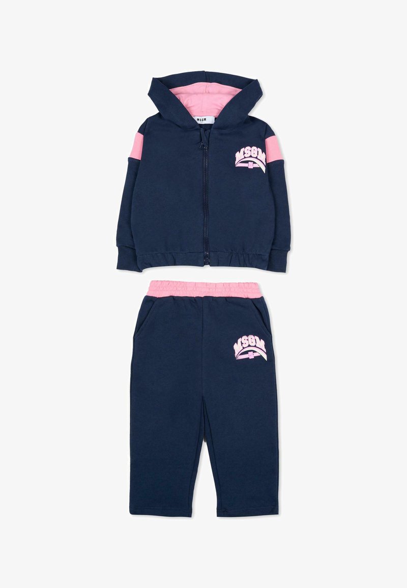 Felpa con zip in navy con dettagli e logo rosa; pantaloni abbinati con vita rosa e logo. Tessuto morbido, design atletico casual, vestibilità confortevole.