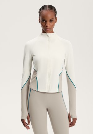 Weiße Sportjacke mit türkisfarbenen Akzenten, Reißverschluss und langen Ärmeln. Bietet ein tailliertes Design und kontrastierende beige Paneele an den Seiten.