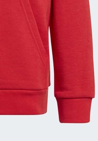 Röd sweatshirt med ribbstickade ärmslut och nederkant, mjuk bomullsblandning och en sidobensficka för ökad funktionalitet.