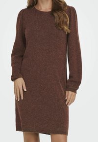 Abito in maglia color bordeaux con maniche lunghe e puff, scollatura rotonda e polsini a costine. Texture morbida con vestibilità comoda, design fino al ginocchio.