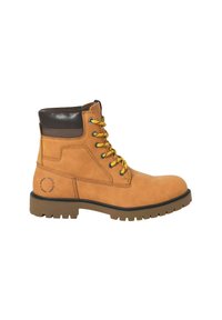 Kožené hnědé šněrovací kotníkové boty s polstrovaným hnědým límcem, silnou podrážkou s drážkami a kruhovým logem blízko paty na bílém pozadí.