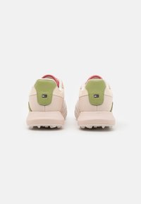 Sneaker beige chiaro con accenti verdi e rosa, tomaia in rete testurizzata, collare imbottito e suola in gomma resistente con motivo di trazione.