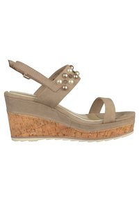 Sandale compensée beige avec une base en liège, un dessus en suède texturé et des perles décoratives sur la bride. Design à bout ouvert avec une bride de cheville.