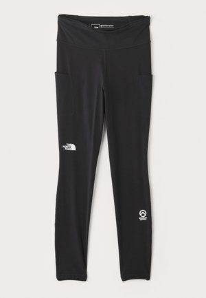 Leggings de sport noirs avec une large taille, deux poches latérales et des logos sur la cuisse et la cheville. Fabriqués en tissu extensible et lisse.