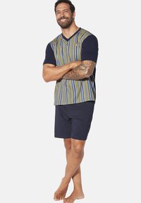 Men's loungewear set consisting of a navy short-sleeve V-neck top with multicolored vertical stripes and matching navy shorts.