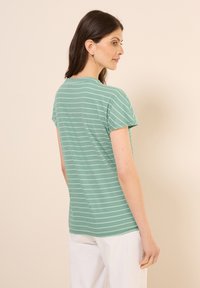 T-shirt vert rayé à manches courtes et col rond, fabriqué en tissu doux, avec des rayures horizontales blanches et une coupe décontractée.