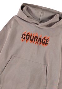 Γκρίζα φούτερ με κουκούλα που διαθέτει μπροστινή τσέπη και την λέξη "COURAGE" σε πορτοκαλί γράμματα που μοιάζουν με φλόγες στο στήθος. Μαλακή υφή.