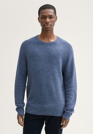 Pull en maille bleu avec un col rond, des manches raglan et un tissu texturé. Présente des poignets et un ourlet côtelés, offrant une coupe décontractée.